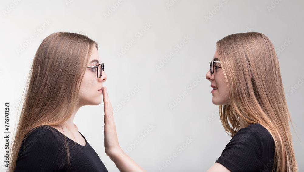Self-silencing act between mirrored women, contemplated - obrazy, fototapety, plakaty 