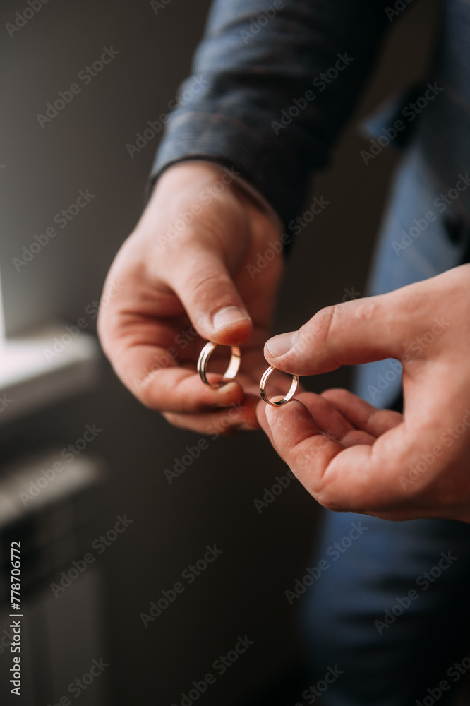 The image is of a pair of hands holding a wedding ring 6992. The image is of a pair of hands holding a wedding ring 6992.