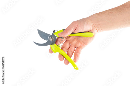 Steel garden secateurs, scissors with green plastic handle in male's hand isolated on a white background.