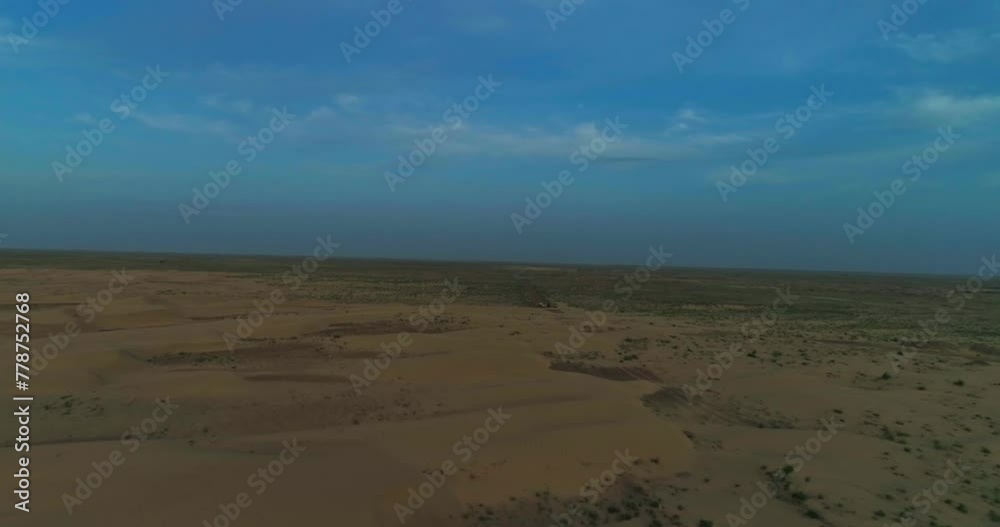 A drone flies over a man in Arab clothes walking on the sand dunes of the desert on the background of the sunset A drone flies over a man in Arab clothes walking on the sand dunes of the desert on the background of the sunset