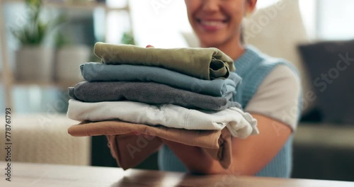 Laundry, clothing and woman holding pile of washing, smile and finished household chores. Hands, folding or fabric for spring clean in home, housewife or housekeeper for sanitary hygiene or organize photo