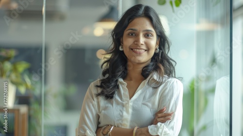 Free Download A young woman with a beaming smile standing confidently in a green office space - GFXLoad
