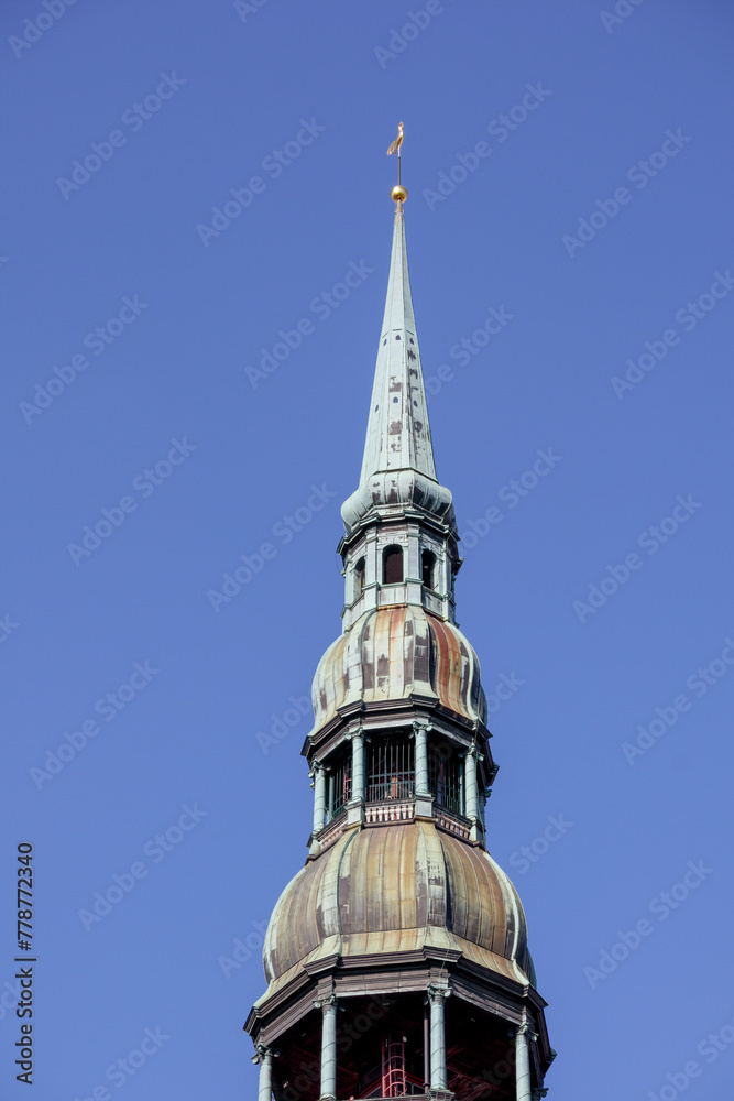 
A tall church tower with a gilded rooster at the top of the tower