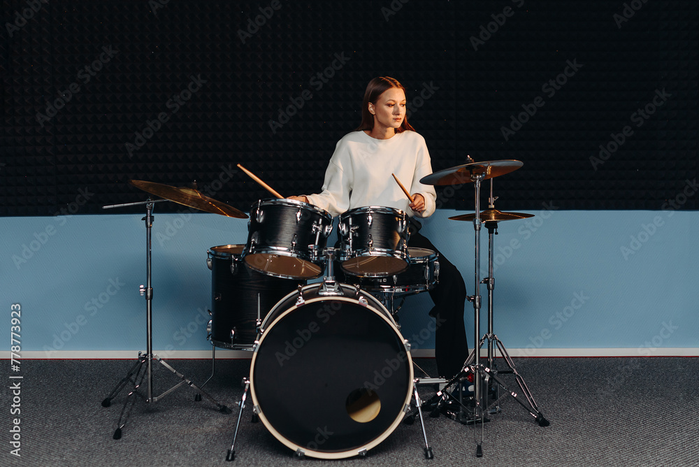 Fototapeta premium young woman playing drum set