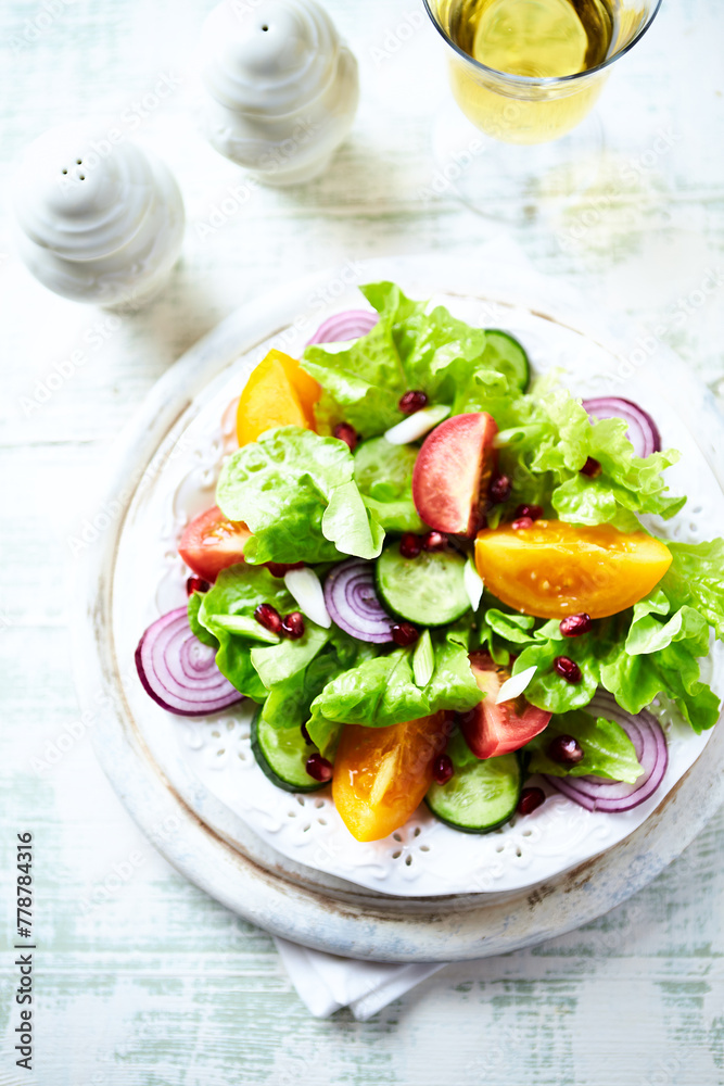 Salad with red and yellow Tomatoes and Pomegranate Seeds on bright wooden Background. Close up.
Salad with red and yellow Tomatoes and Pomegranate Seeds on bright wooden Background. Close up.