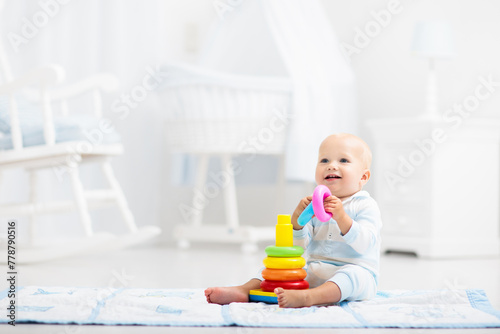 Baby playing with toy pyramid. Kids play