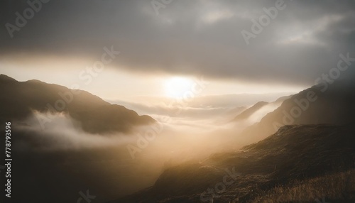 epic gloomy landscape close up moonlight breaks through heavy clouds and illuminates sections of the gloomy valley dissipating in the fog cinematic