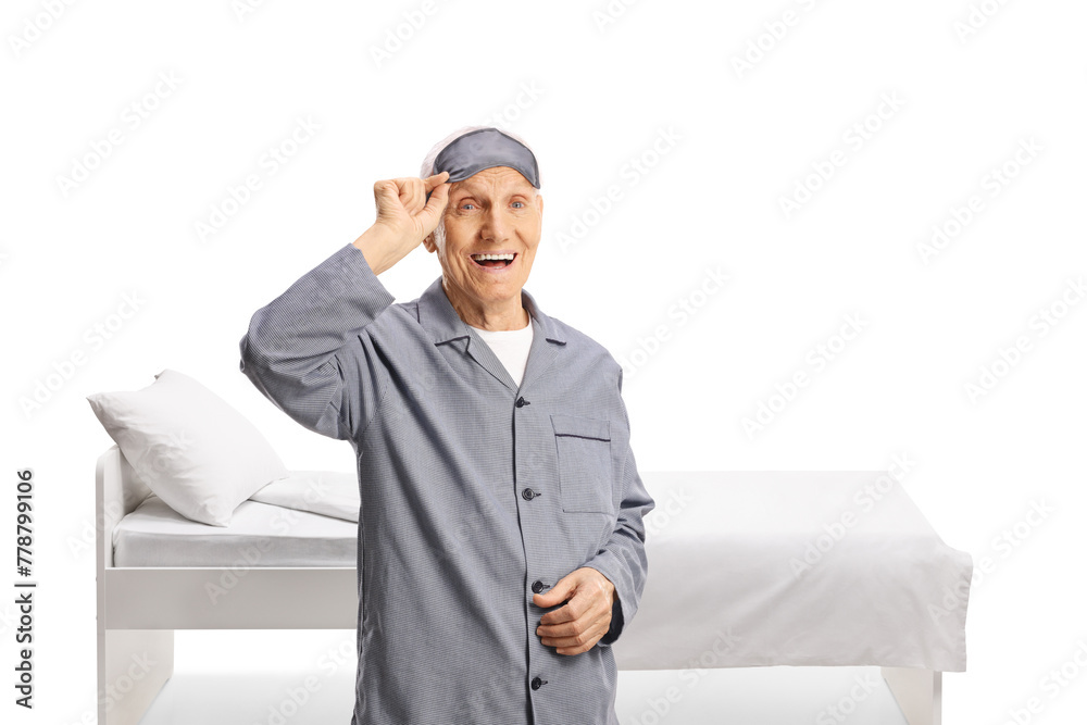 Elderly man in pajamas taking off a sleeping mask