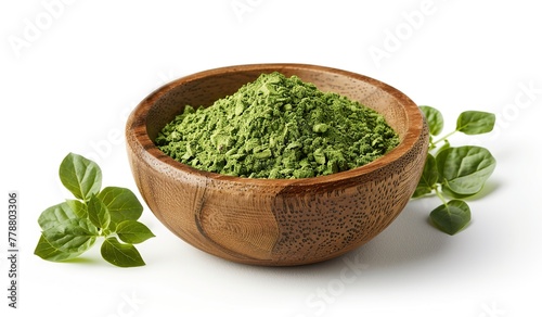 Organic green matcha tea powder in a wooden bowl with fresh leaves