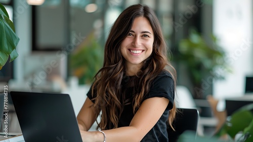 Smiling Young Woman Working on Laptop in Modern Office Space. Casual Business Style, Freelancer at Work. Contemporary Worker Portrait. AI