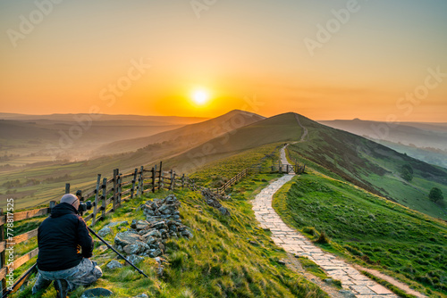 Landscape photographer at Mam Tor hill  in Peak District taking picture at sunrise photo
