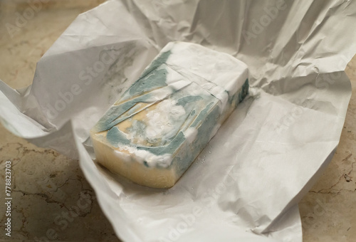 Fotografía a spoiled piece of blue cheese lying on a sheet of paper