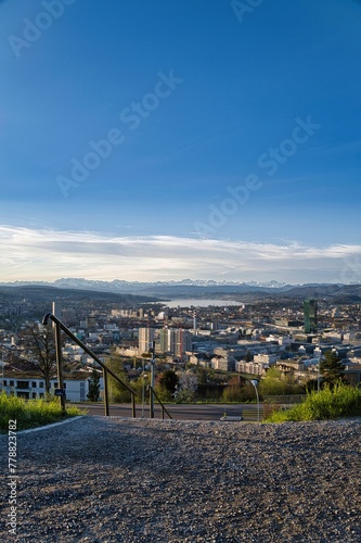 Path overlooking the city of Zurich in spring with snowy Swiss Alps in the background from the Waid