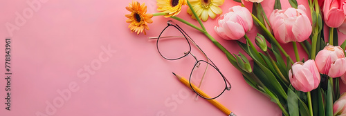 Blooming flowers, rimless glasses and mechanical pencil on a pink chalkboard background with copy space for Teacher’s Day or Women’s Day concept photo