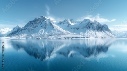  A mountain range is mirrored in a serene lake's surface, with snowy peaks in the distance