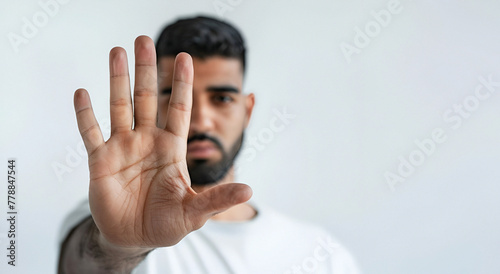 A man making a stop gesture with his hand against a white background. Copy space. 
