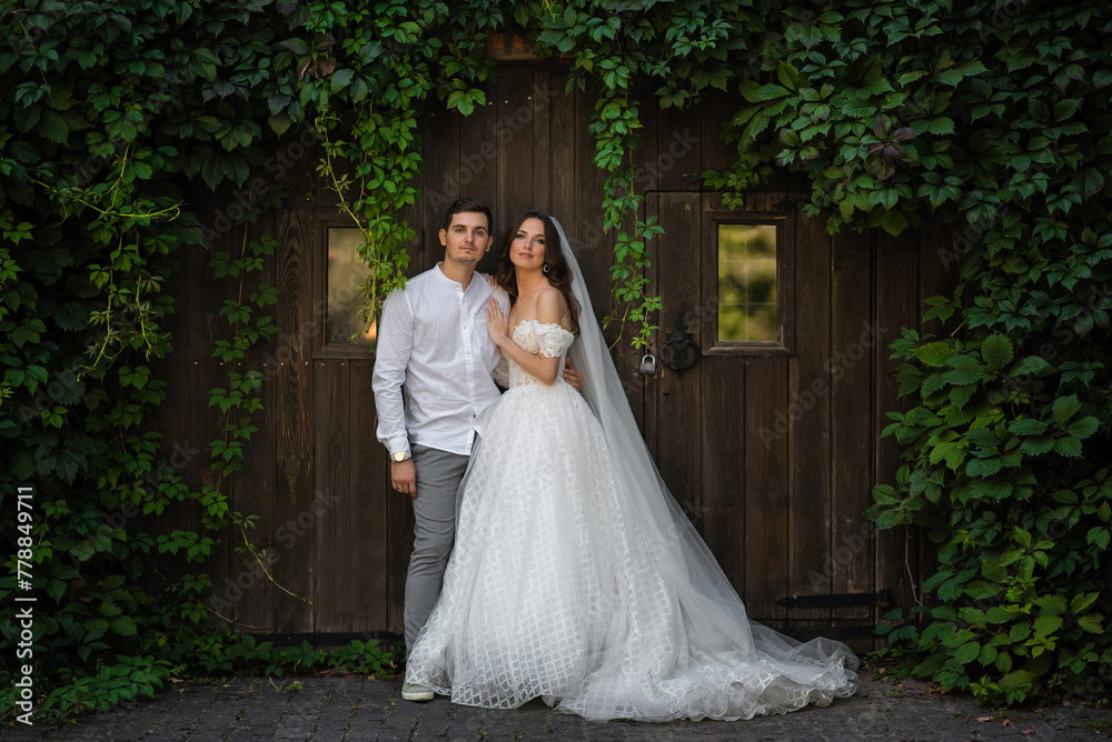 European white newlywed couple standing near wooden wall European white newlywed couple standing near wooden wall