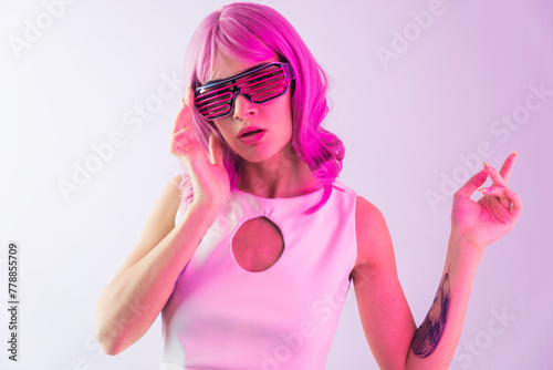 Beautiful woman with stylish clothes and pink colored hair portrait in studio