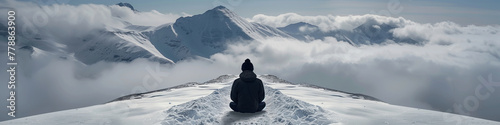 Majesty atop the frozen summit. A lone figure sits serenely on a majestic snow-covered mountain peak, surrounded by a vast expanse of white photo