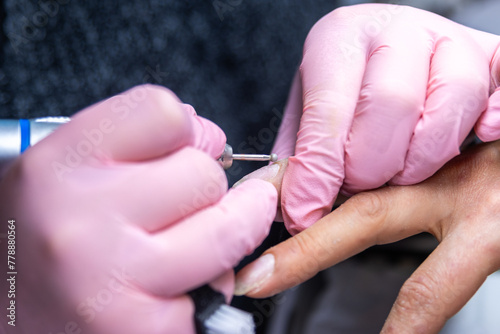Nail technician meticulously shaping with an electric file