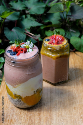 Passion fruit smoothie bowl and jar with  strawberry and bluberry topping 