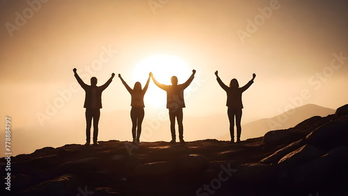 Success concept, Silhouette of a four people with arms raised up in the mountains at sunset