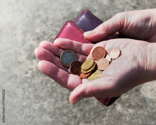 Pink purse and euro coins in female hands, selective focus.	
