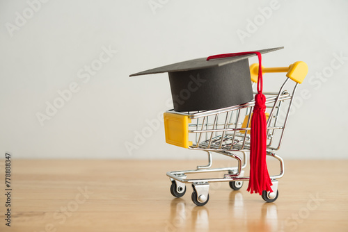 Graduation cap university or college degree in shopping trolley on wooden table white wall background copy space. Job fair, recruitment, employee search vacancy jobs, employer search resume concept.