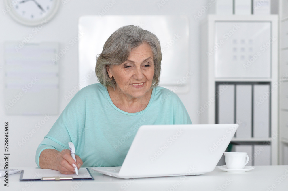 Senior business woman working in office with laptop Senior business woman working in office with laptop