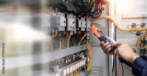 Electricity and electrical maintenance service, Engineer hand holding AC voltmeter checking electric current voltage at circuit breaker terminal and cable .
