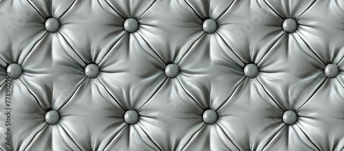 A closeup of a white tufted leather couch with black buttons, showcasing the symmetry and pattern in monochrome photography