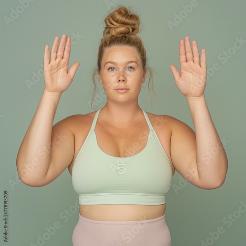 Plus size woman with hands up in green sports bra