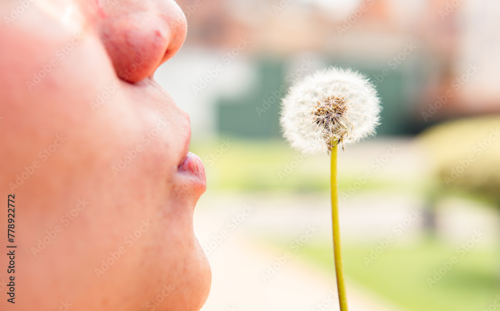 Closeup of woman's mouth blowing dandelion Closeup of woman's mouth blowing dandelion