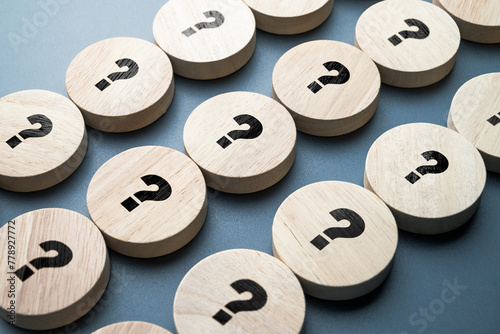 Many question marks on round wood blocks arranged in the rows, many questions need the answers, system, processing, test, or FAQS concept