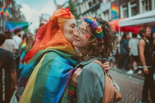 LGBT Couple Embracing and Kissing in the Street with Rainbow Flag in Background during Pride Parade