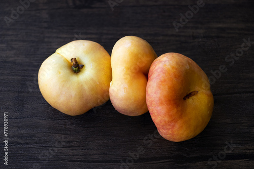 closeup of flat peaches on the wooden table photo