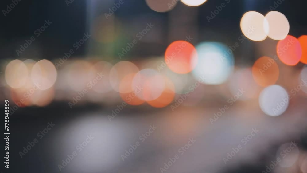 Beautiful bokeh in a dark blurry background at night on the walking street with the people. The round colorful bokeh shine from buildings and shops in the city lifestyle. Abstract concept.