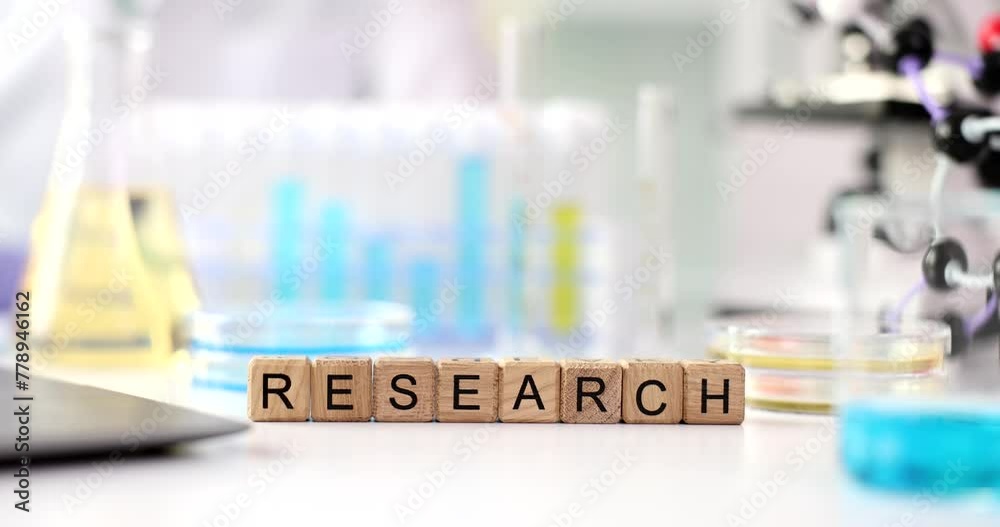The laboratory has wooden cubes with the inscription research, close-up. Chemical experience, scientific discovery The laboratory has wooden cubes with the inscription research, close-up. Chemical experience, scientific discovery