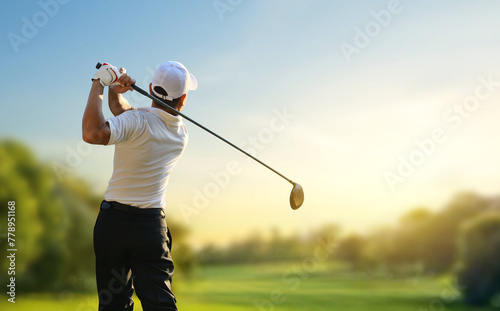 Golfer hit sweeping driver after hitting golf ball down the fairway with sunrise background. photo