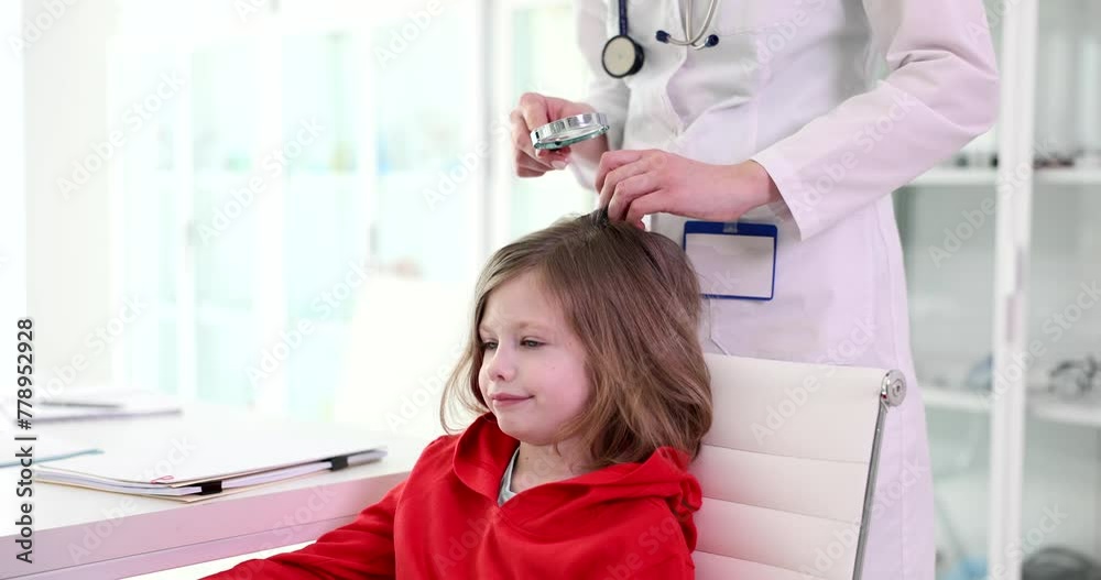 The doctor looks through a lupa at the child hair close-up. A visit to a trichologist, slowmotion