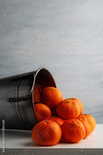 closeup of mandarin oranges in silver metal bucket