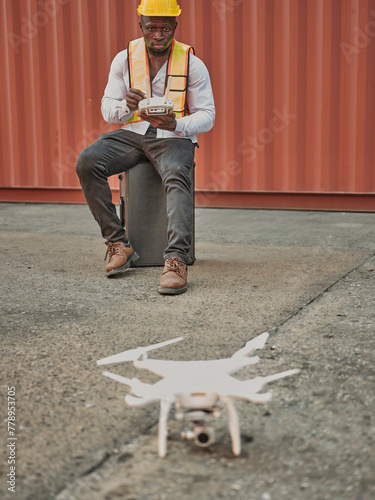 Engineer or  worker piloting drone at ontainer cargo ship at shipping port. video surveillance or industrial inspection photo