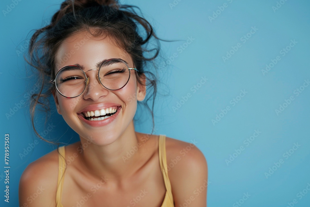 Casual young multiethnic woman with eyeglasses smiling on blue background Casual young multiethnic woman with eyeglasses smiling on blue background