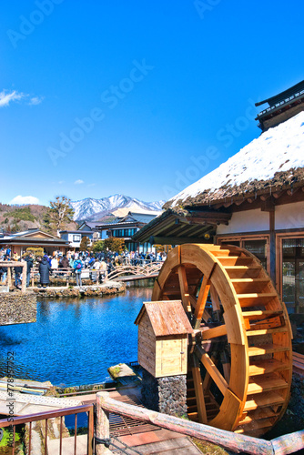 YAMANASHI, JAPAN-MARCH 10,2024: Groups Tourists looking fish in clear pool Mineral water stream flows from Mount Fuji in Oshino Hakkai village, Traditional Japanese style, Landmark. photo