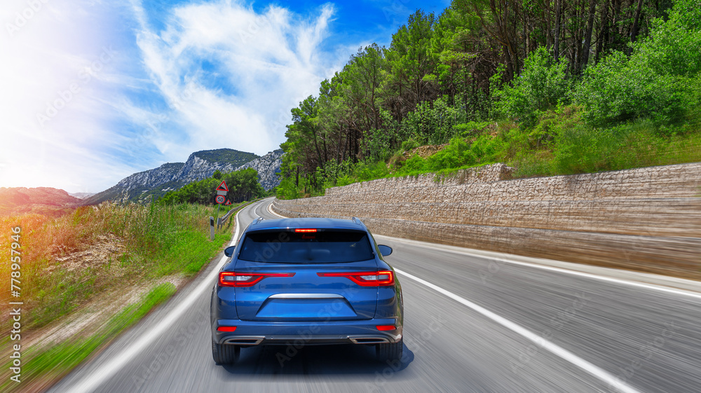 Blue car on asphalt road. Asphalt road view in countryside at beautiful sunset