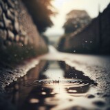 Puddles fill an empty country lane, as rain creates ripples in the water
