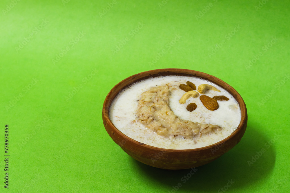 Eid mubarak with lachchha sewai or saemiya payasam or shevai served on earthen bowl for iftar during ramadan month. This sweet dish is made with vermicelli, milk, dry fruits during eid festival. Eid mubarak with lachchha sewai or saemiya payasam or shevai served on earthen bowl for iftar during ramadan month. This sweet dish is made with vermicelli, milk, dry fruits during eid festival.