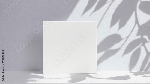 Soft shadows from leaves on a white wall. Square white mockup