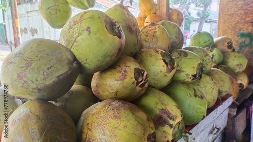 Piles of young coconuts sold in a stall for sale photo