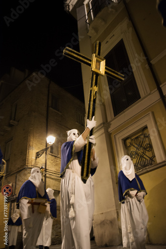 Hooded penitents during the famous Good Friday procession in Chieti (Italy) carry the cross with the effigy of Jesus